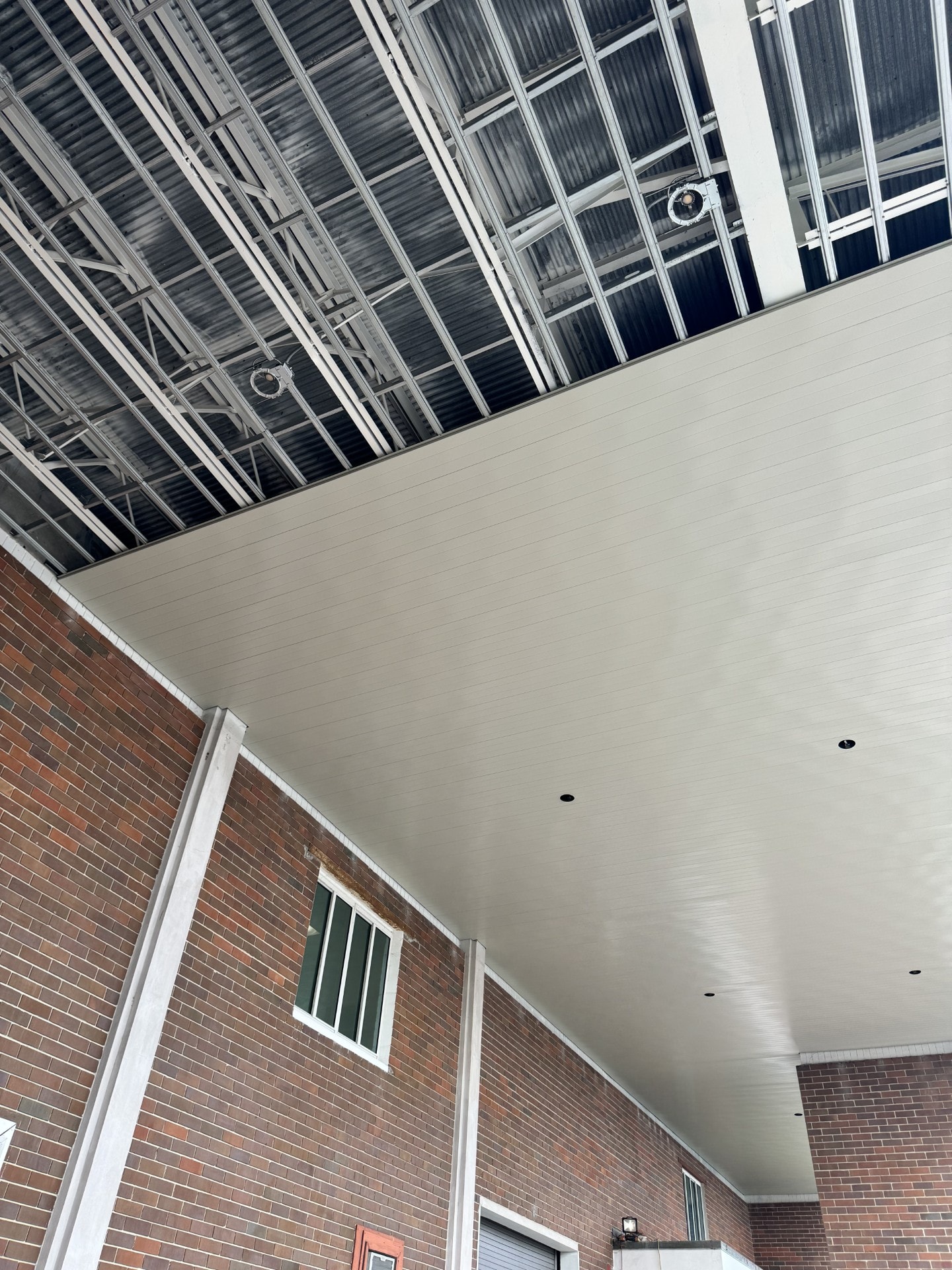Finished ceiling panel installation on brick commercial building