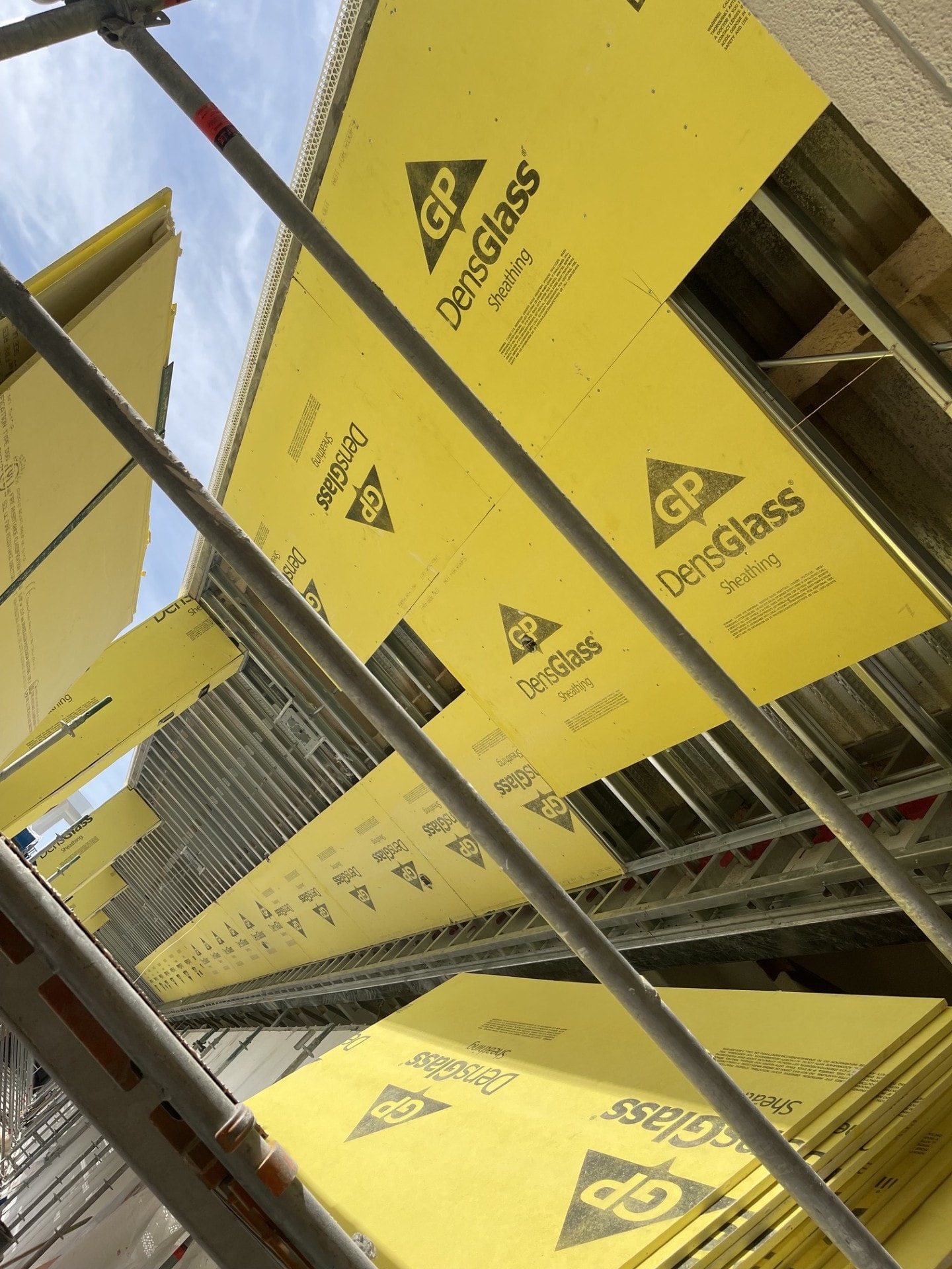 DensGlass sheathing boards staged on scaffolding for exterior installation
