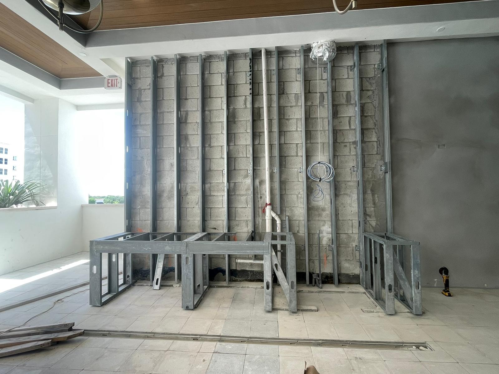 Interior steel stud framing against CMU block wall with wood ceiling
