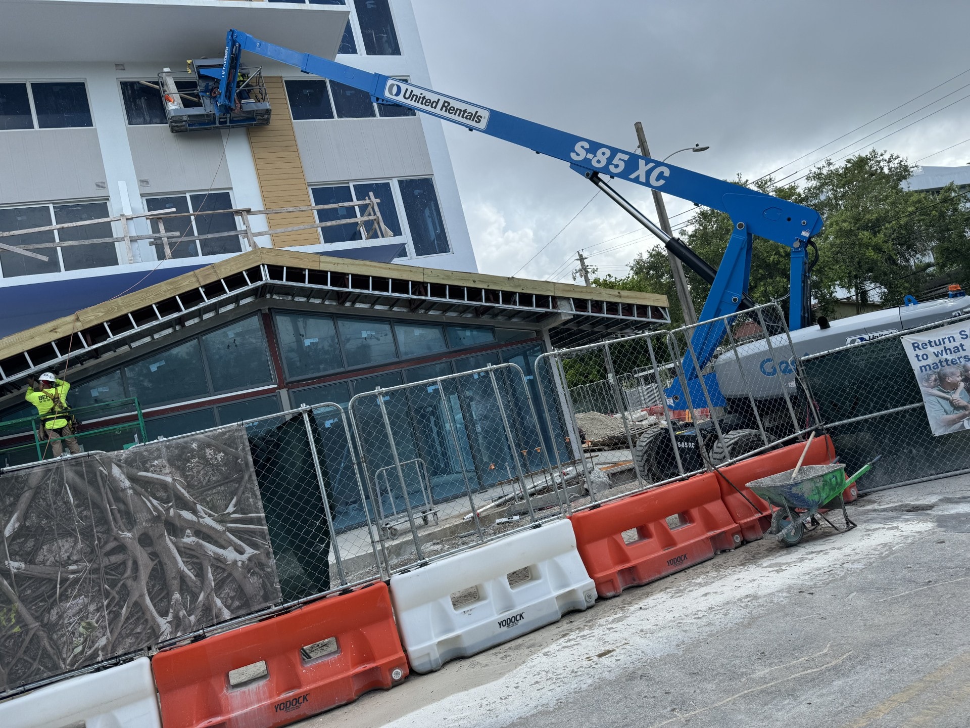 Exterior framing and EIFS work with United Rentals crane on active site